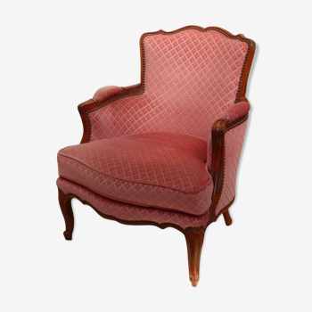 Fauteuil bergère vintage en velours rose.