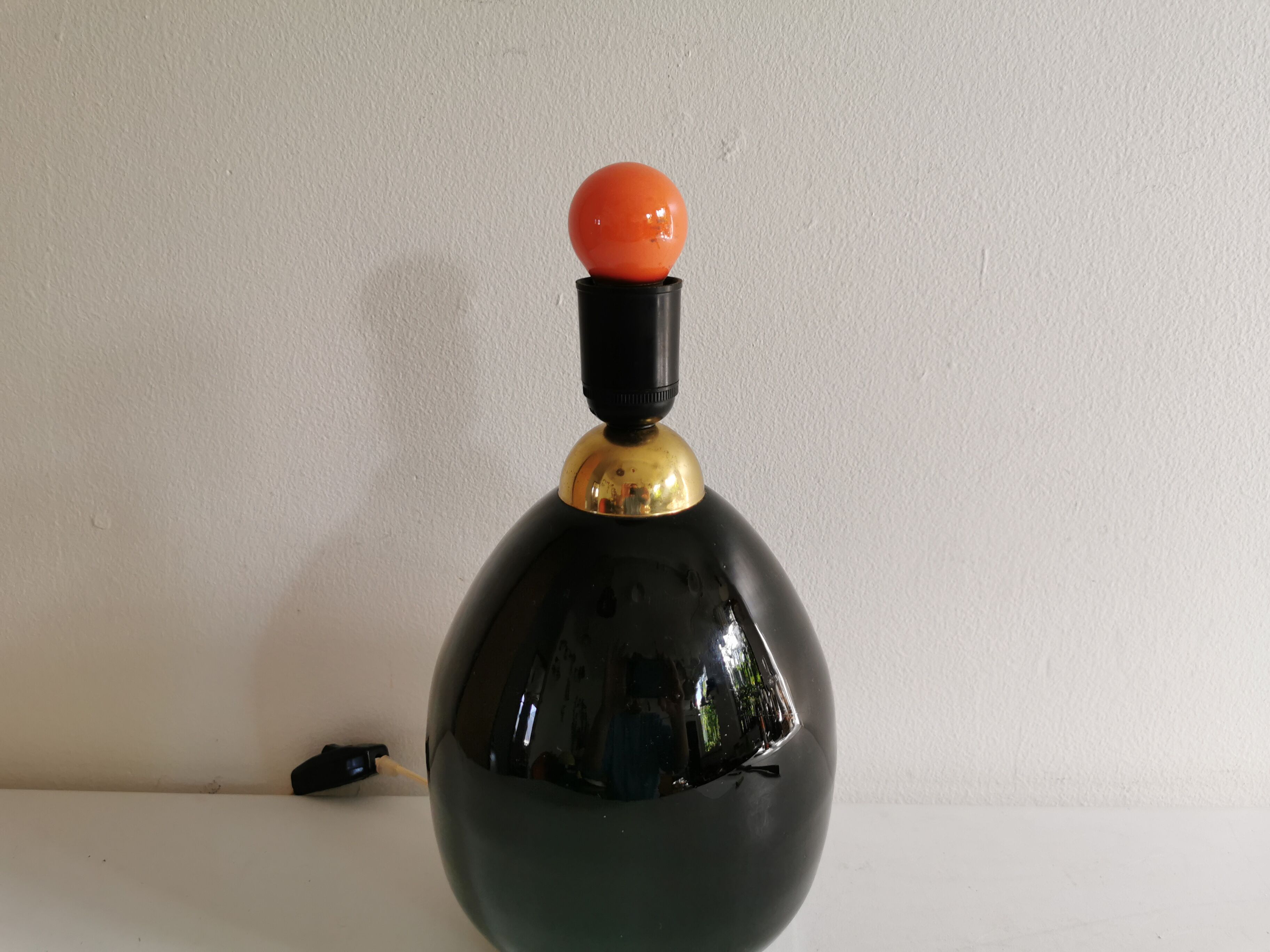 Table lamp, made of handmade coal-black glass, with brass coloured top.