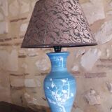 Large blue porcelain lamp with white flowers (cherry blossoms) on wooden stand.