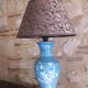 Large blue porcelain lamp with white flowers (cherry blossoms) on wooden stand.