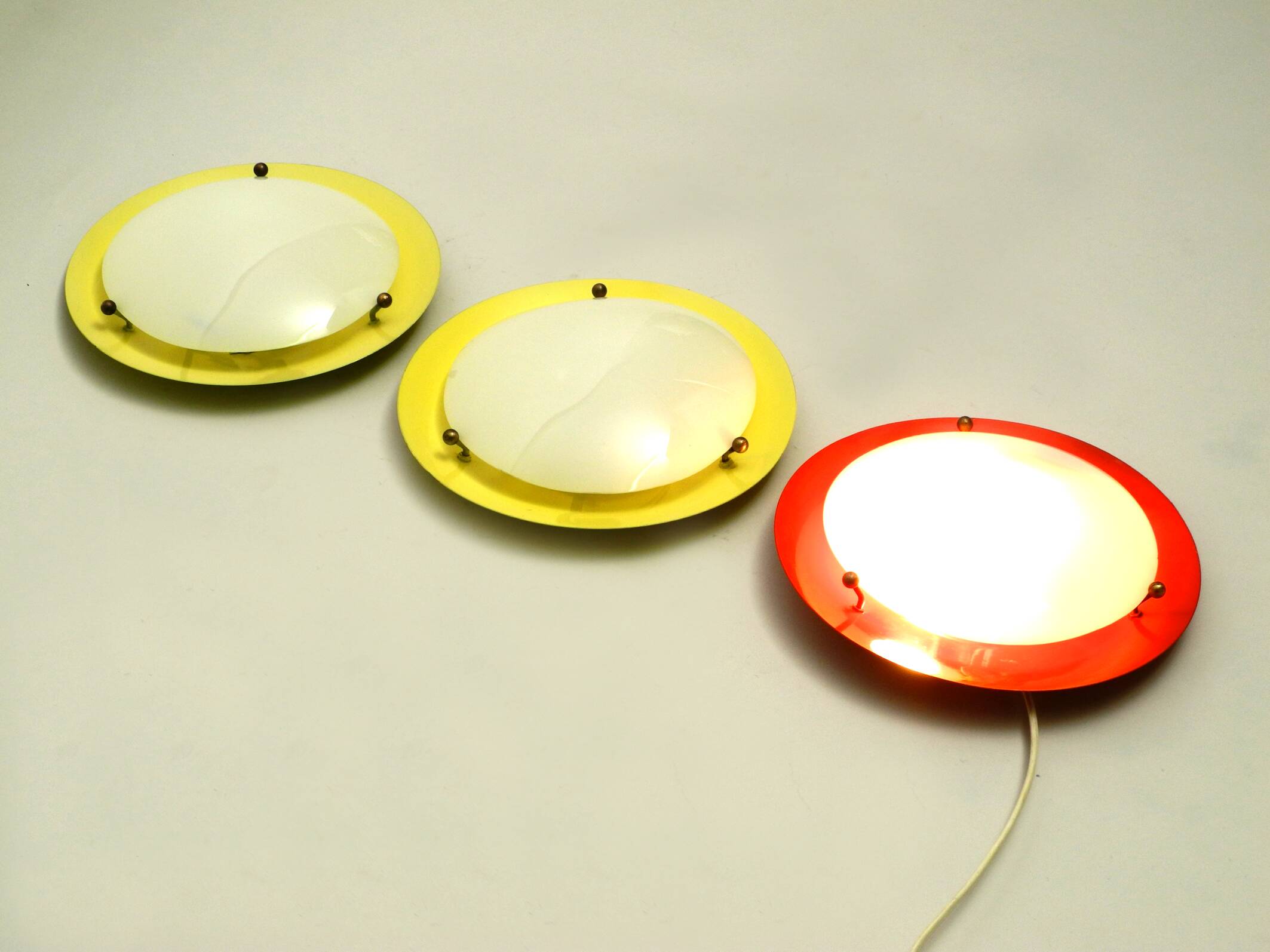 Three round 1950s wall or ceiling lamps made of metal and plexiglass shades