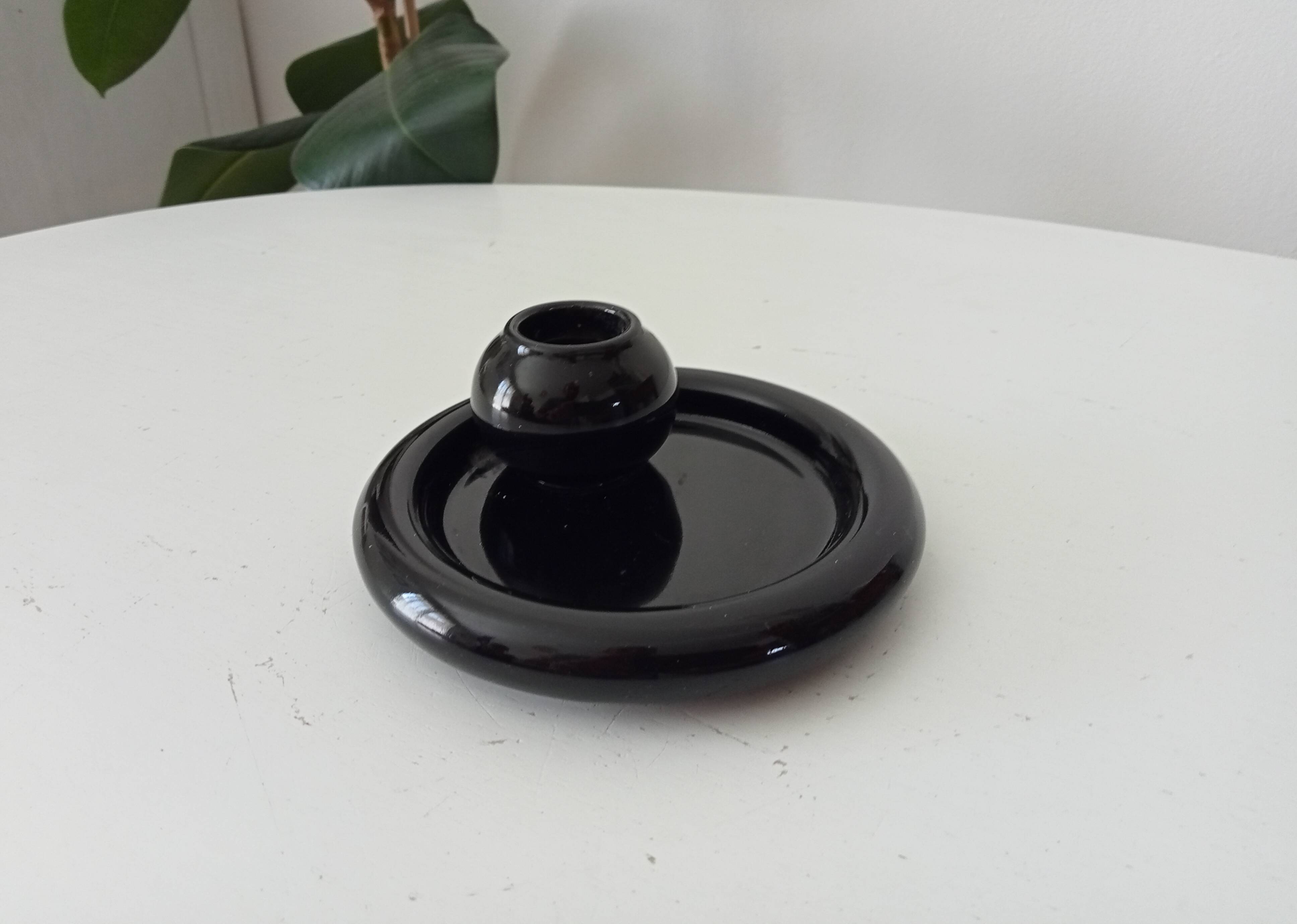 Vintage black ceramic candle holder on a bowl