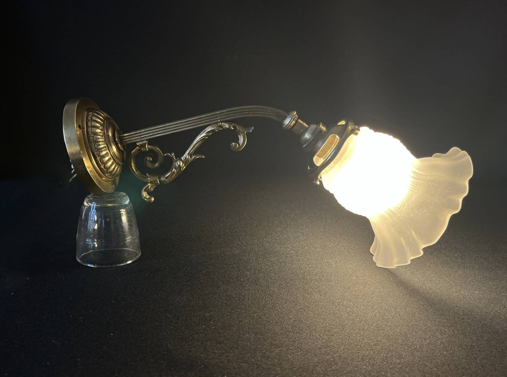 20th century Louis XVI style swan neck wall light in arabesque bronze and pleated glass tulip.