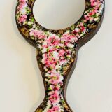 Vintage enameled metal hand mirror on wood