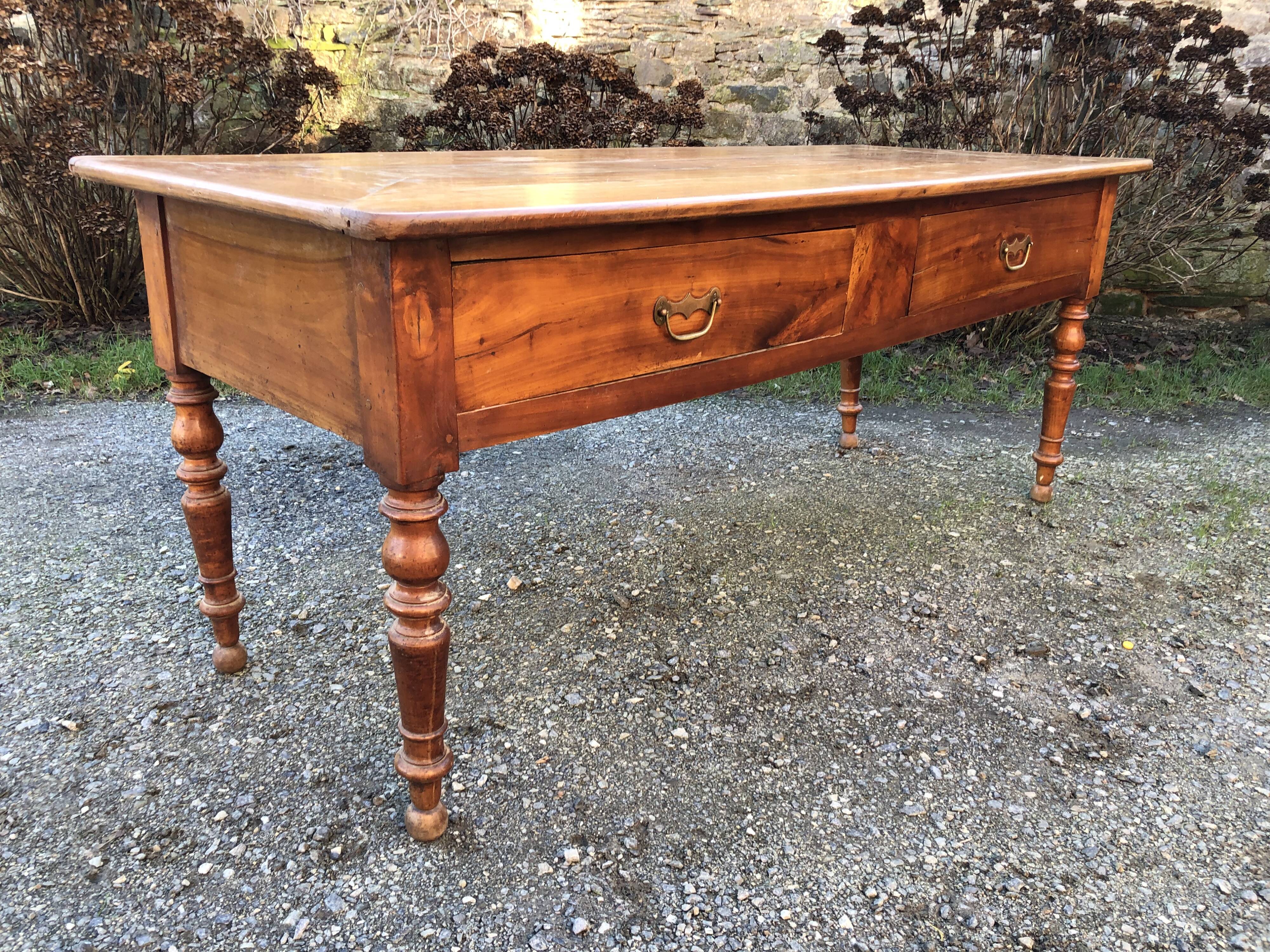 Antique cherry farmhouse table with turned legs and 2 drawers.