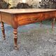 Antique cherry farmhouse table with turned legs and 2 drawers.