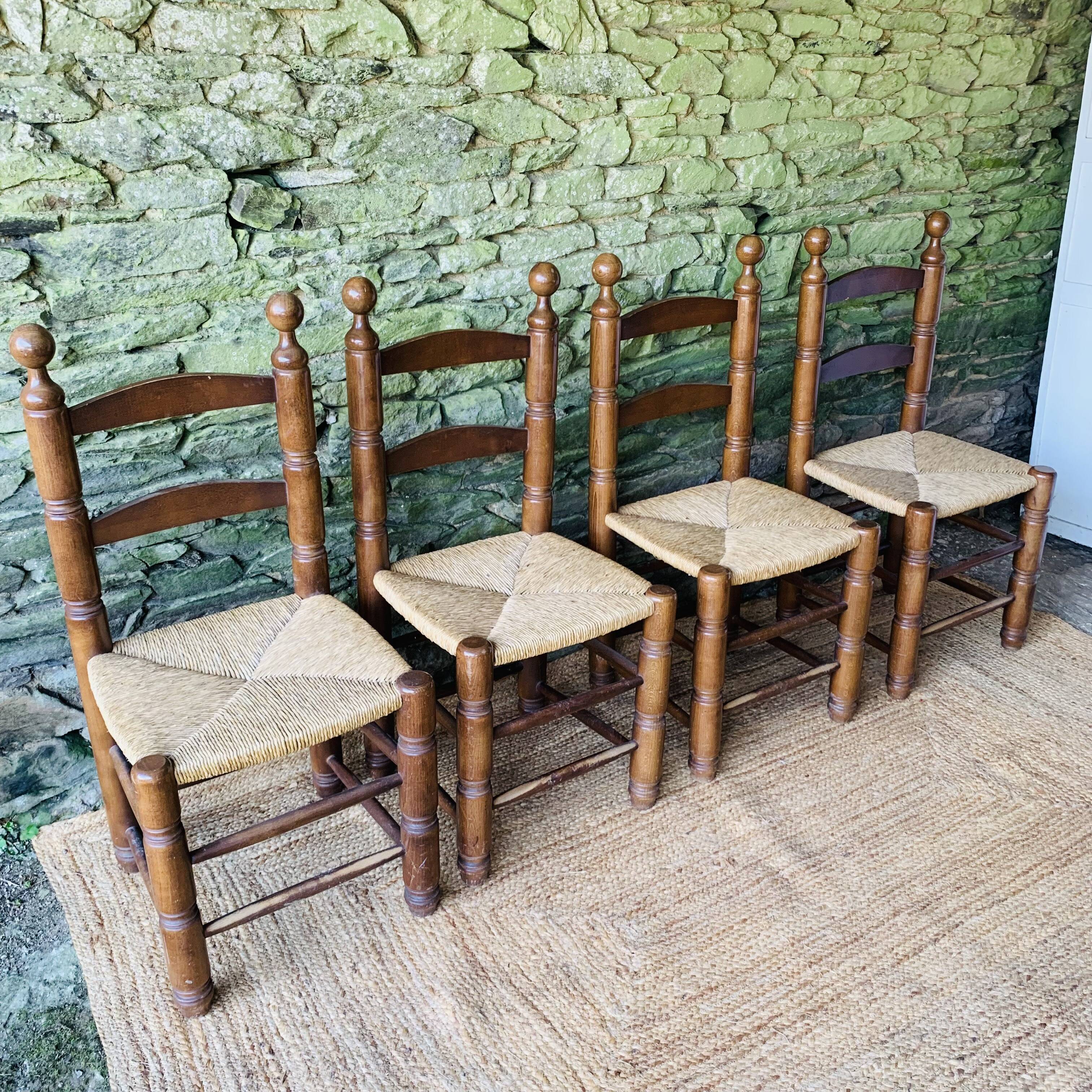 Set of 4 solid wood chairs with straw seats.