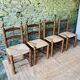 Set of 4 solid wood chairs with straw seats.