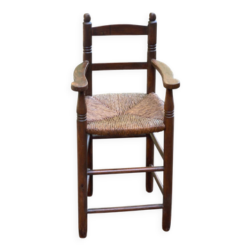 Child's high chair booster from the 19th century in solid wood with rush seating.