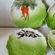 4 hand-decorated earthenware plates with vegetable and green leaf designs.