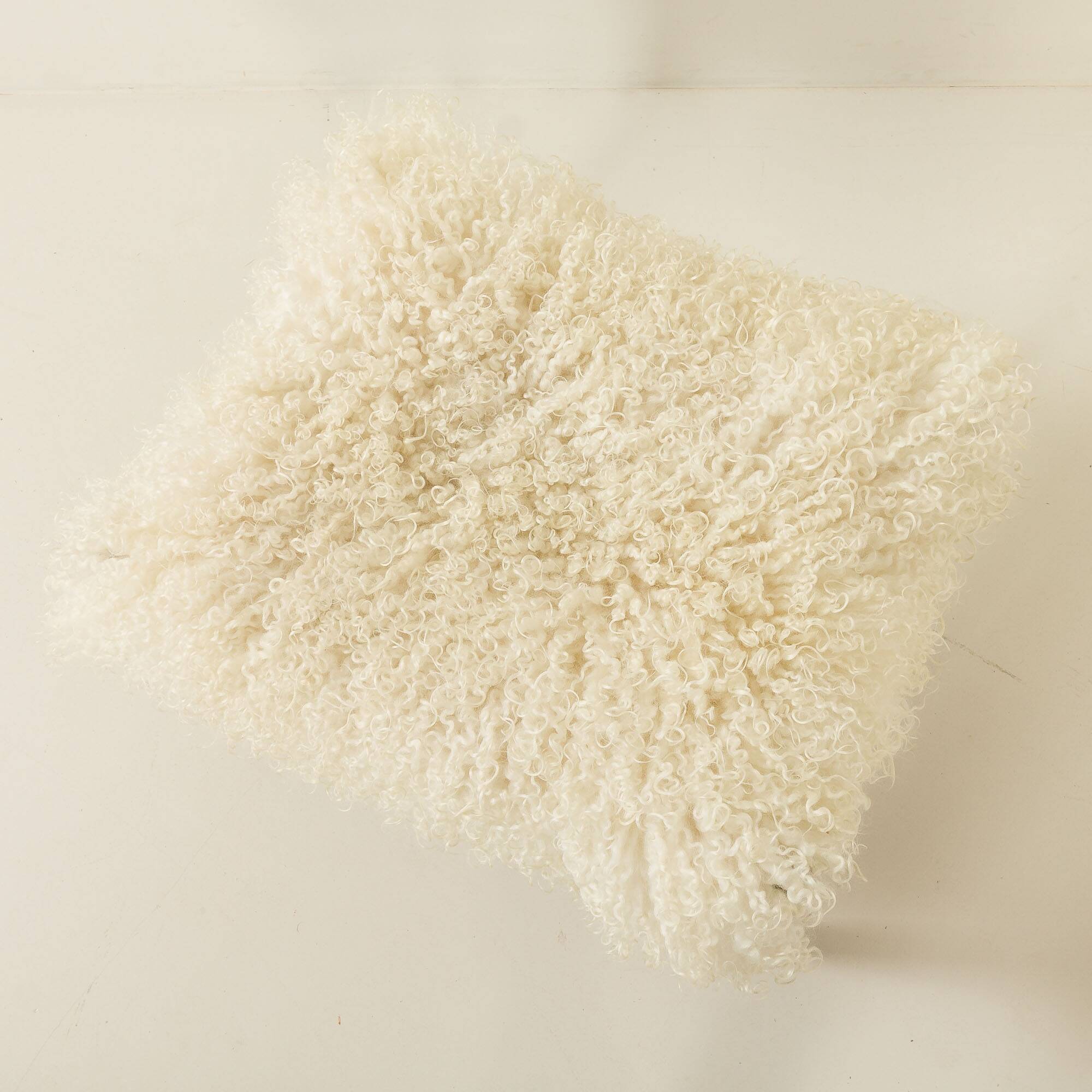 Pouf en teck danois des années 60 recouvert de peau de mouton à poils longs.