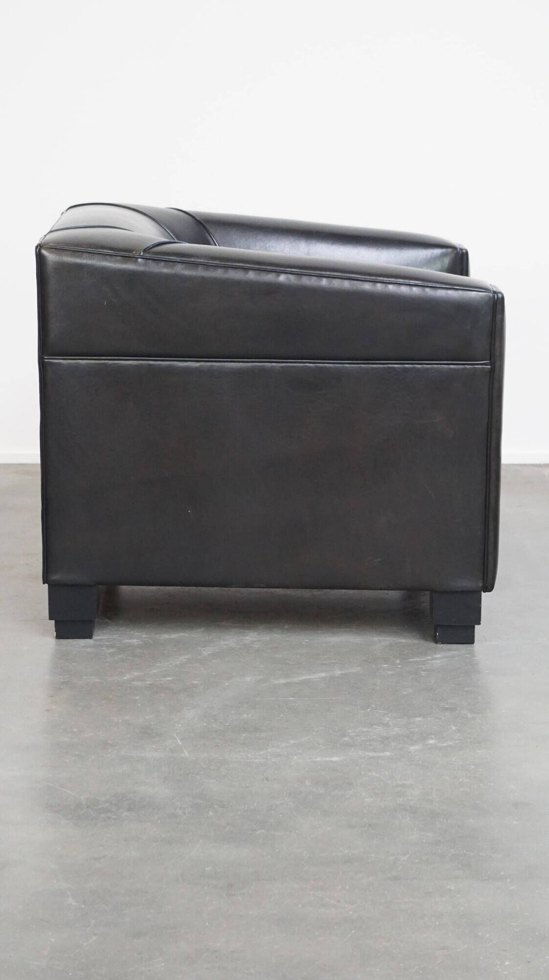Very comfortable black Art Deco design armchair, made of sheepskin leather