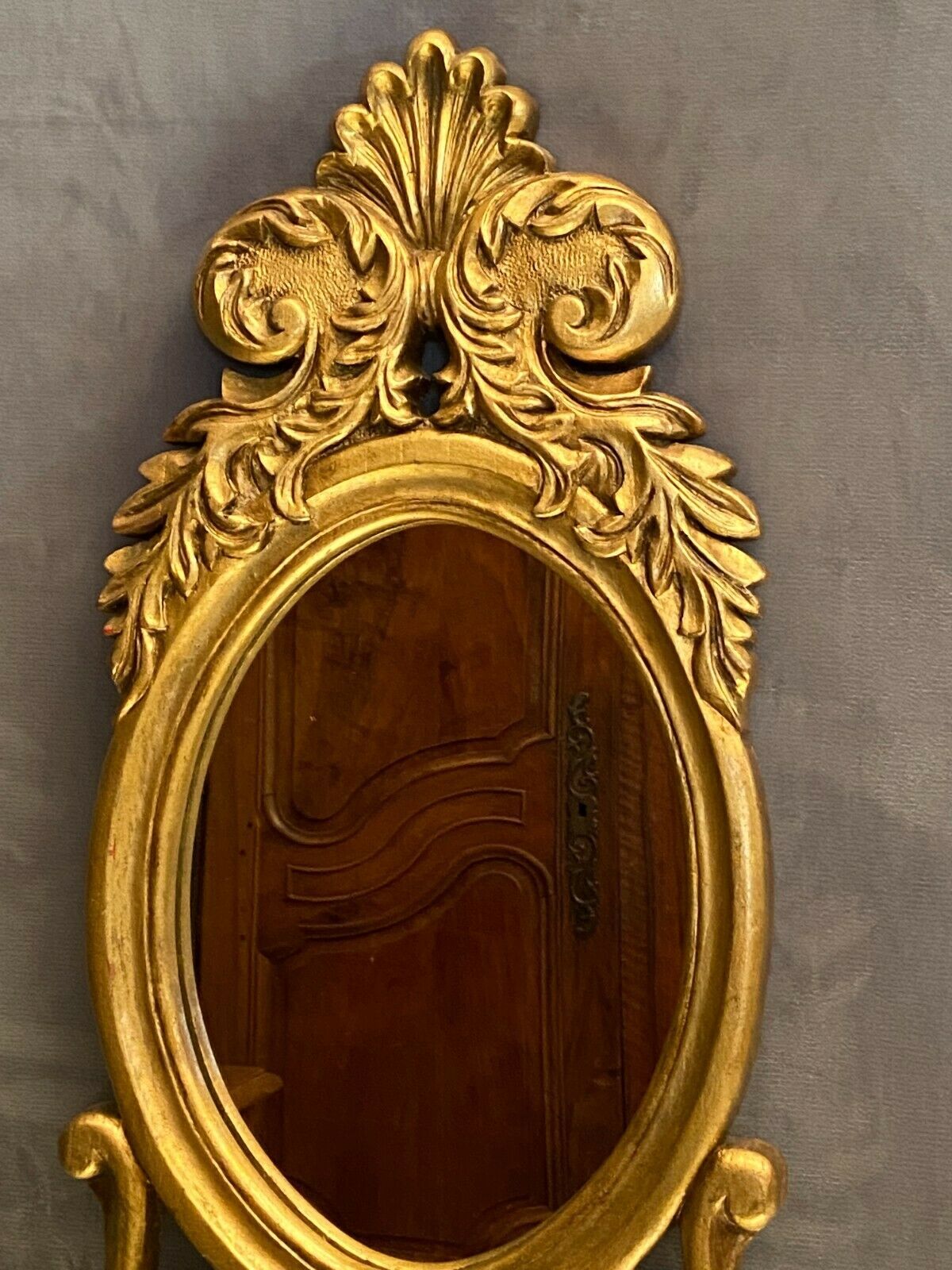 Oval view mirror in gilded wood with leafy decoration in Regency style