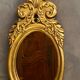 Oval view mirror in gilded wood with leafy decoration in Regency style