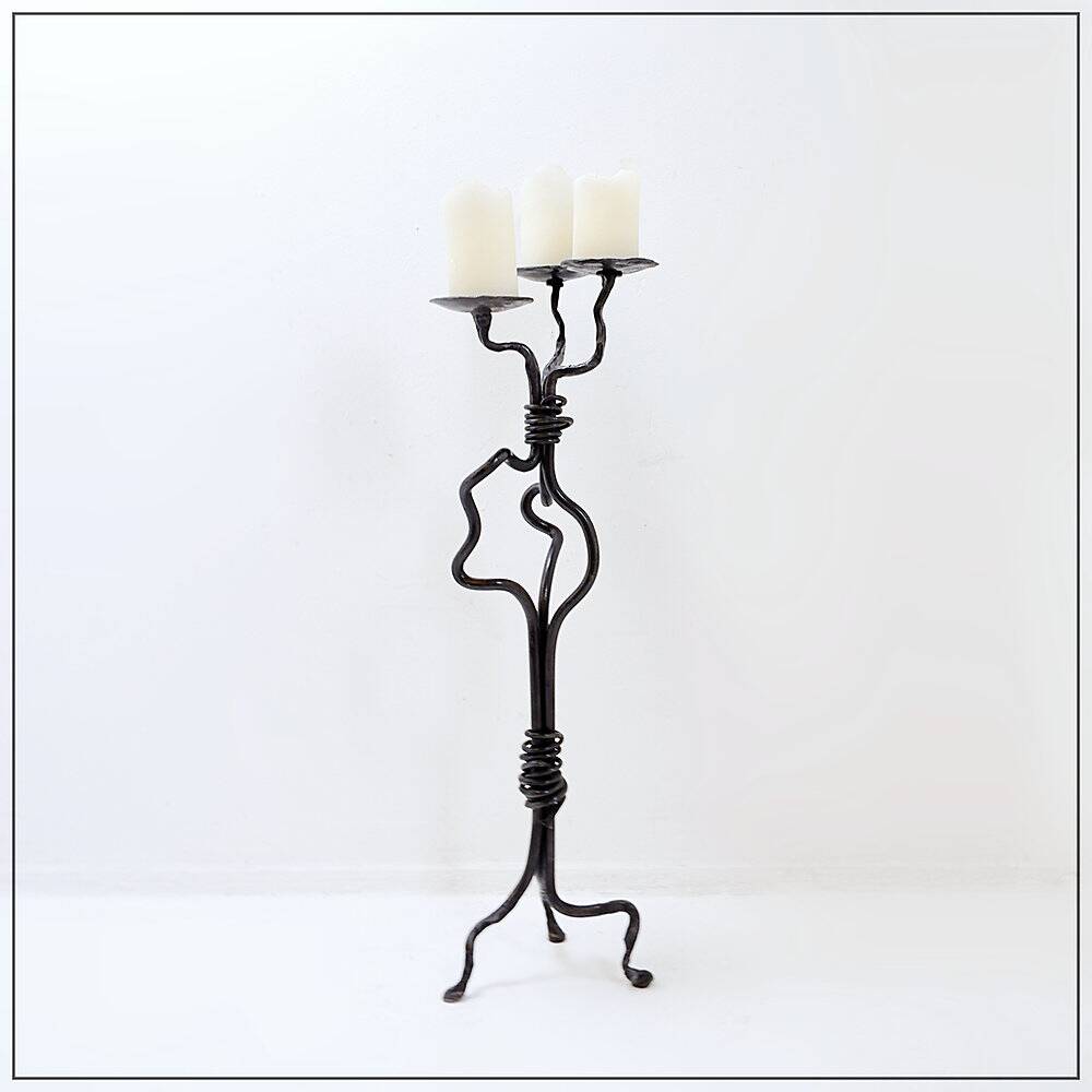 Large wrought iron candelabrum with an abstract design and three candle holders.