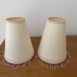 2 off-white fabric lampshades with pink and white tassels