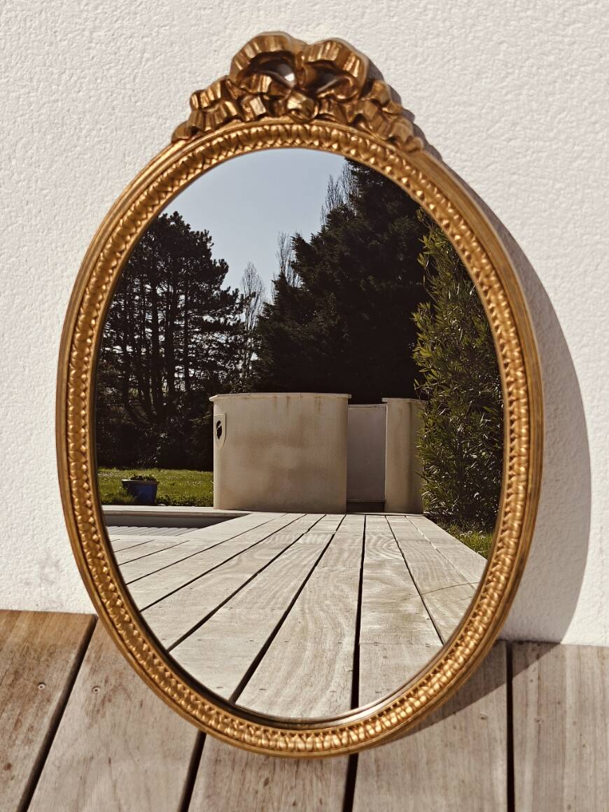 Authentic chic vintage oval mirror, in gilded wood, in baroque style.