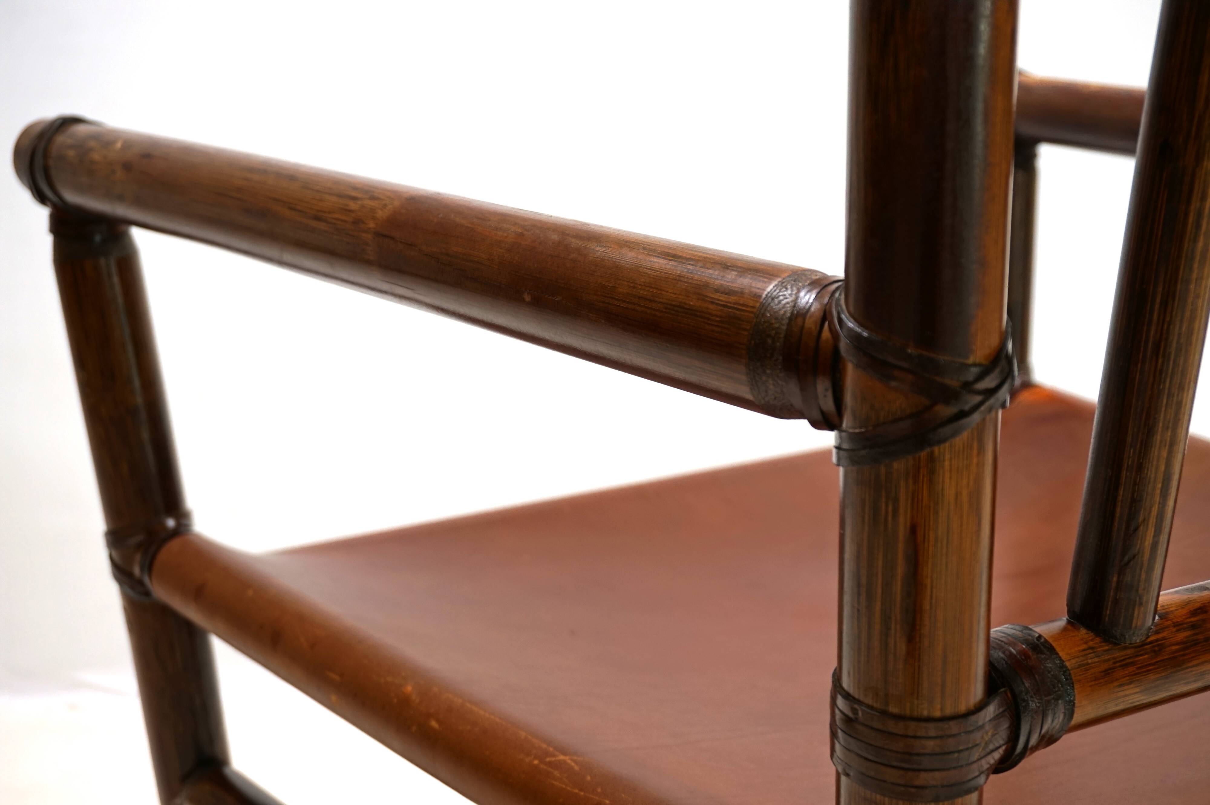 Fauteuil Manou en rotin et assise en cuir, 1960