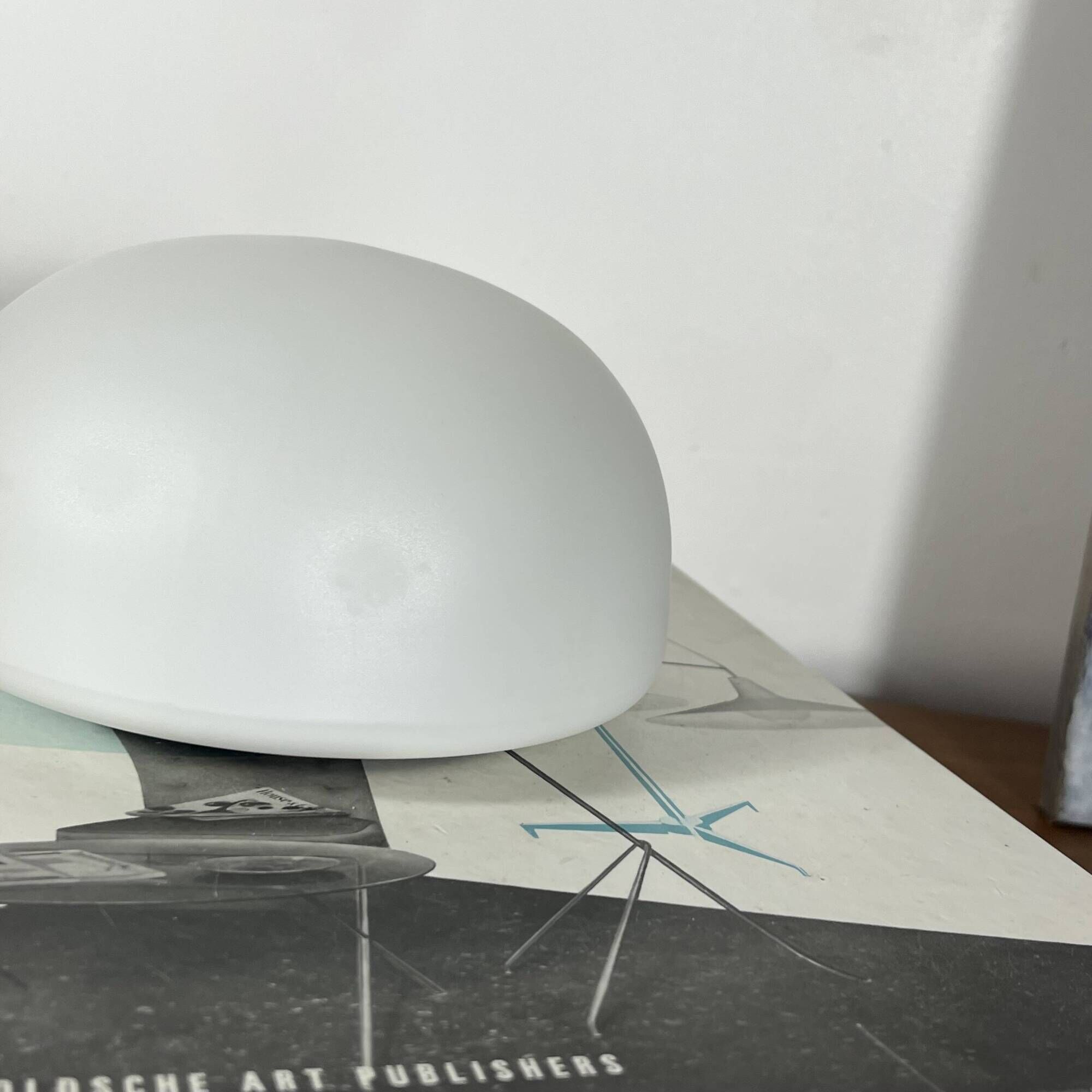 Small antique ceiling light or wall sconce with a frosted white glass half-moon.
