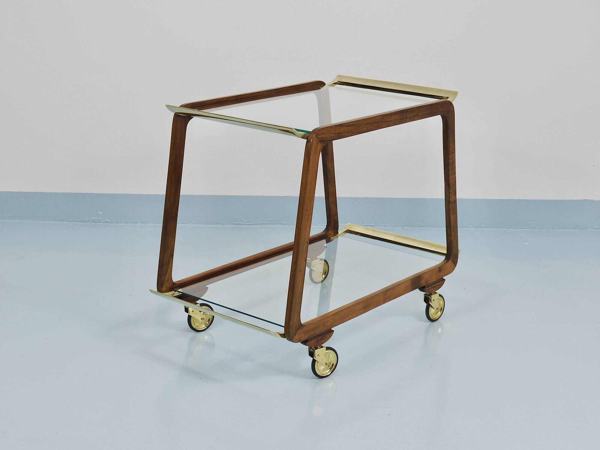 May include: A mid-century modern bar cart with a dark wood frame and two c