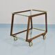 May include: A mid-century modern bar cart with a dark wood frame and two c