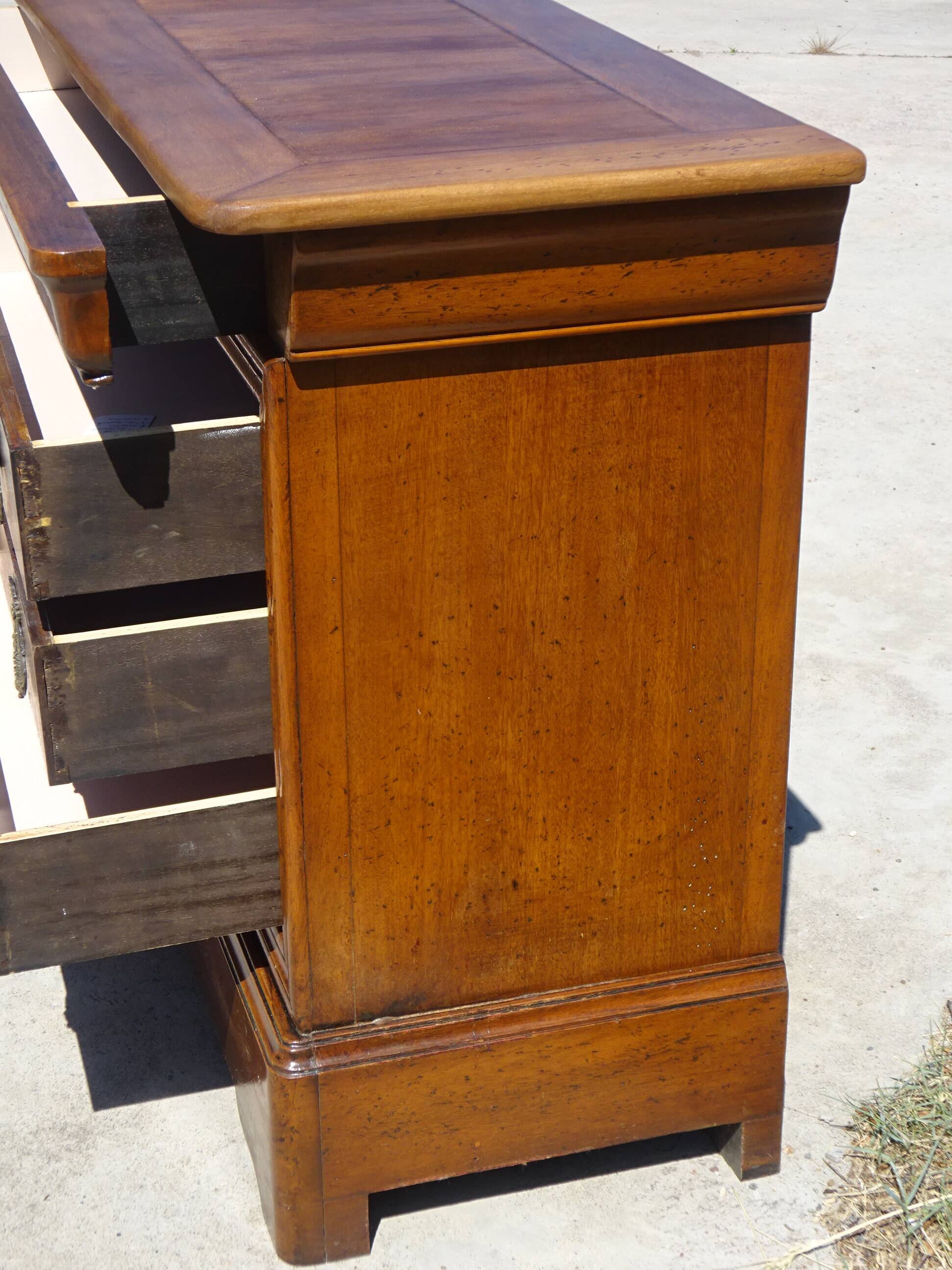 Chest of drawers with decorated handles in the Louis XVI style.