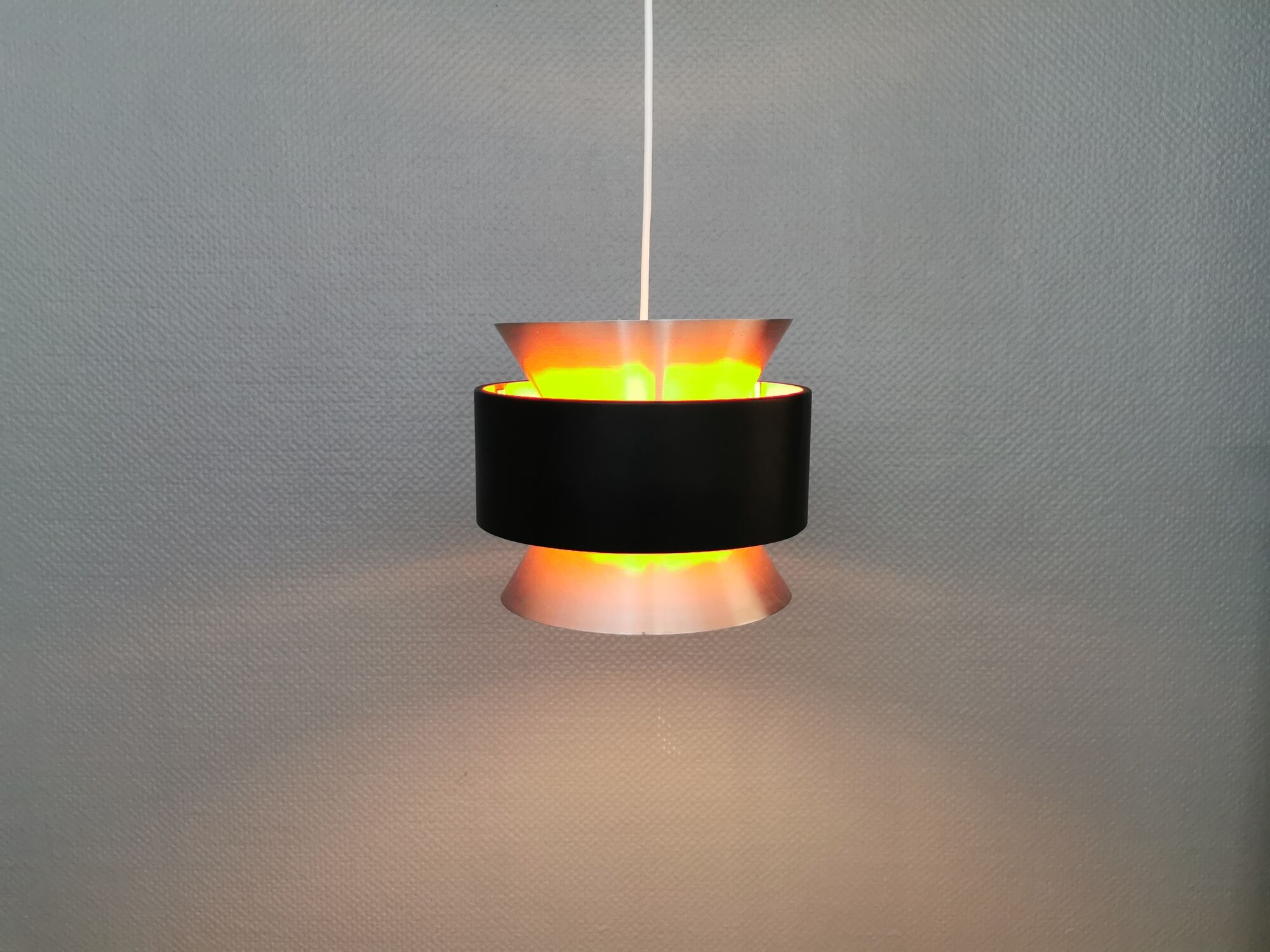 Hanging lamp,  of silver coloured aluminium with black "ring" and orange inner contrast lacquer.