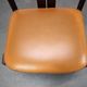 Vintage German sculptural chair from the 1970s in wood with orange faux leather.