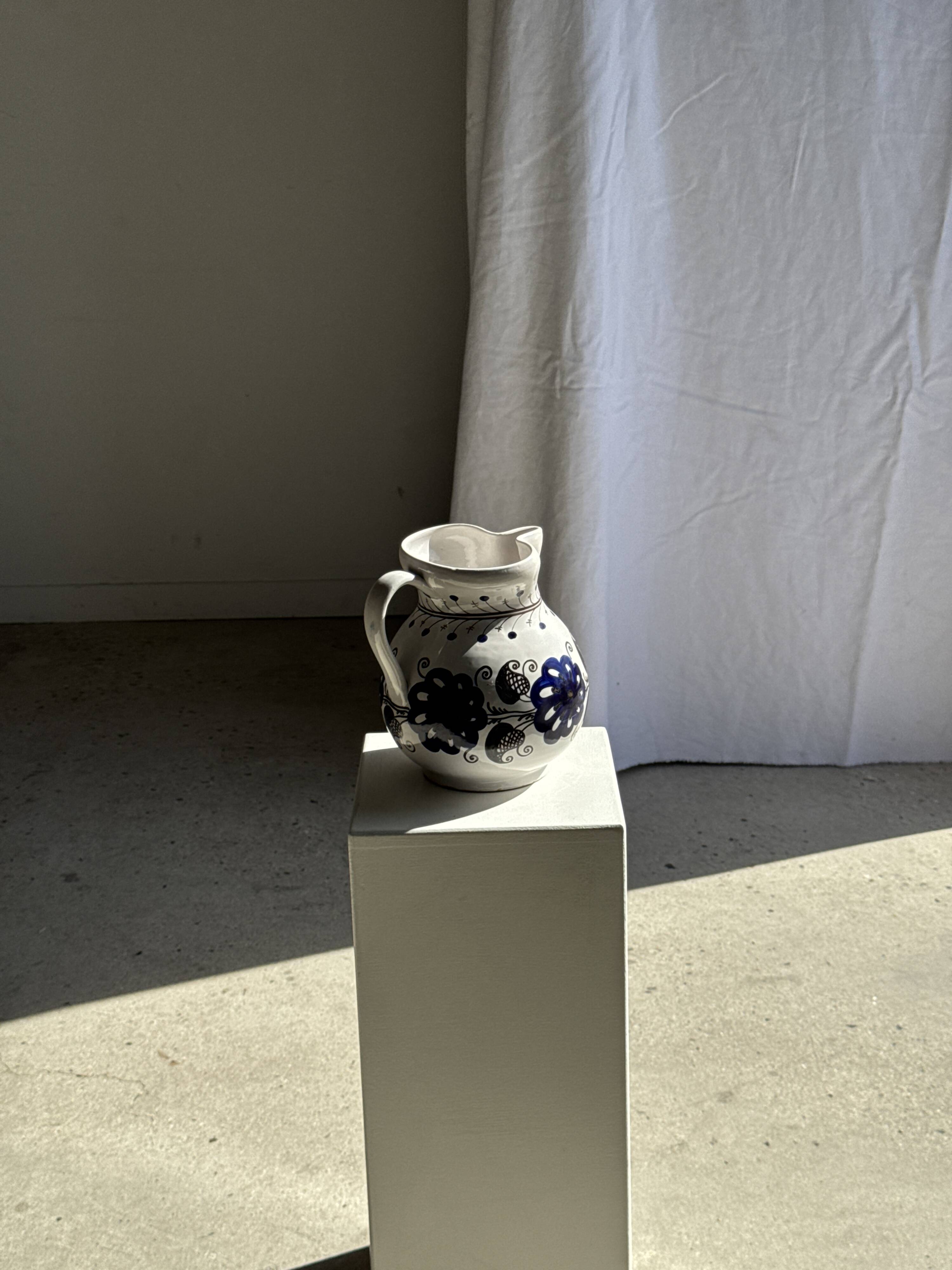 Very large vintage ceramic carafe in white glazed with blue floral decoration.