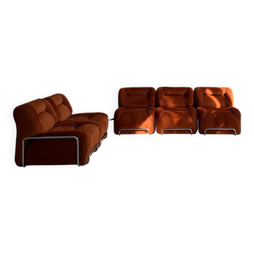 Canapé modulaire avec table basse en velours orange brûlé.