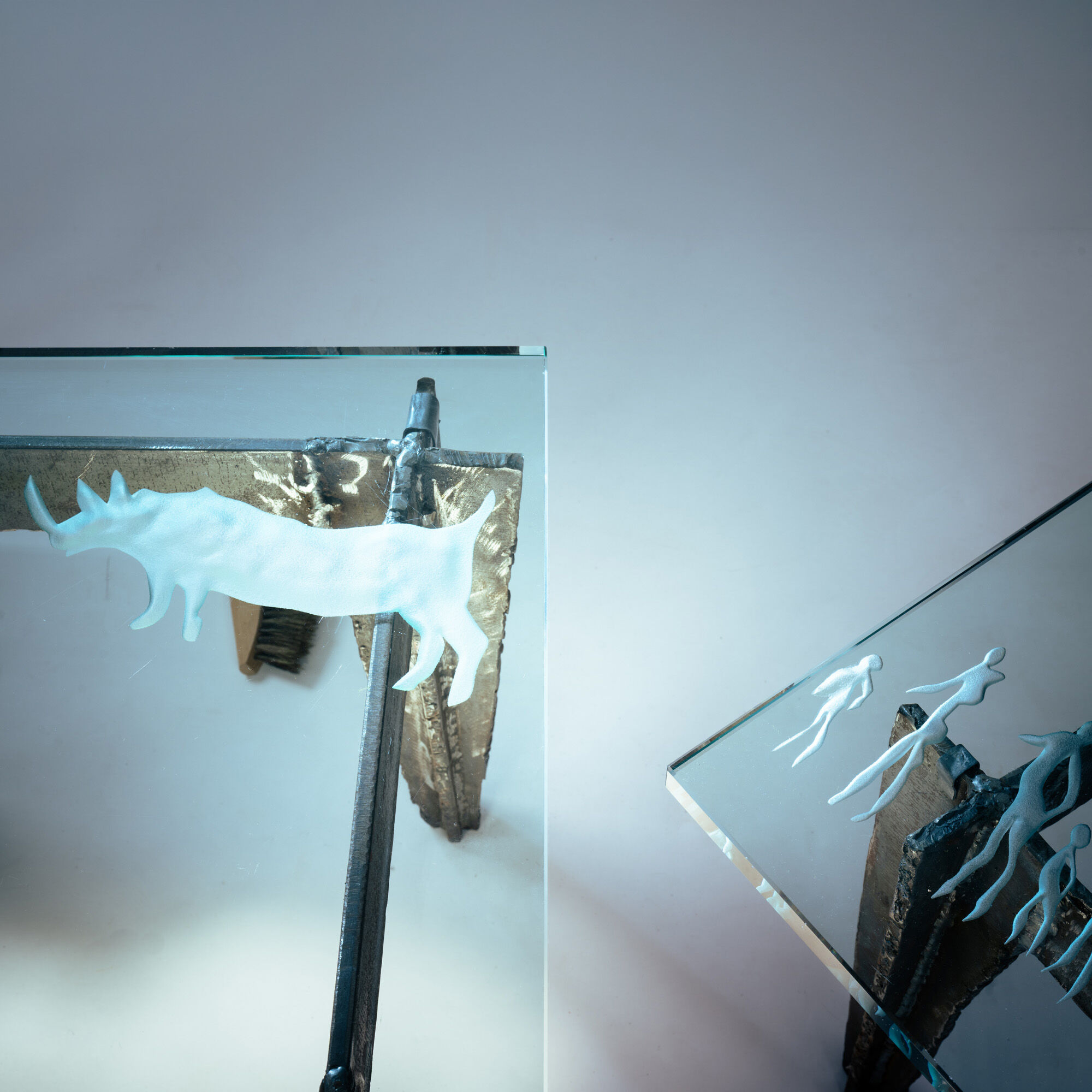 2 brutalist steel side tables with primitive  scene motifs etched glass