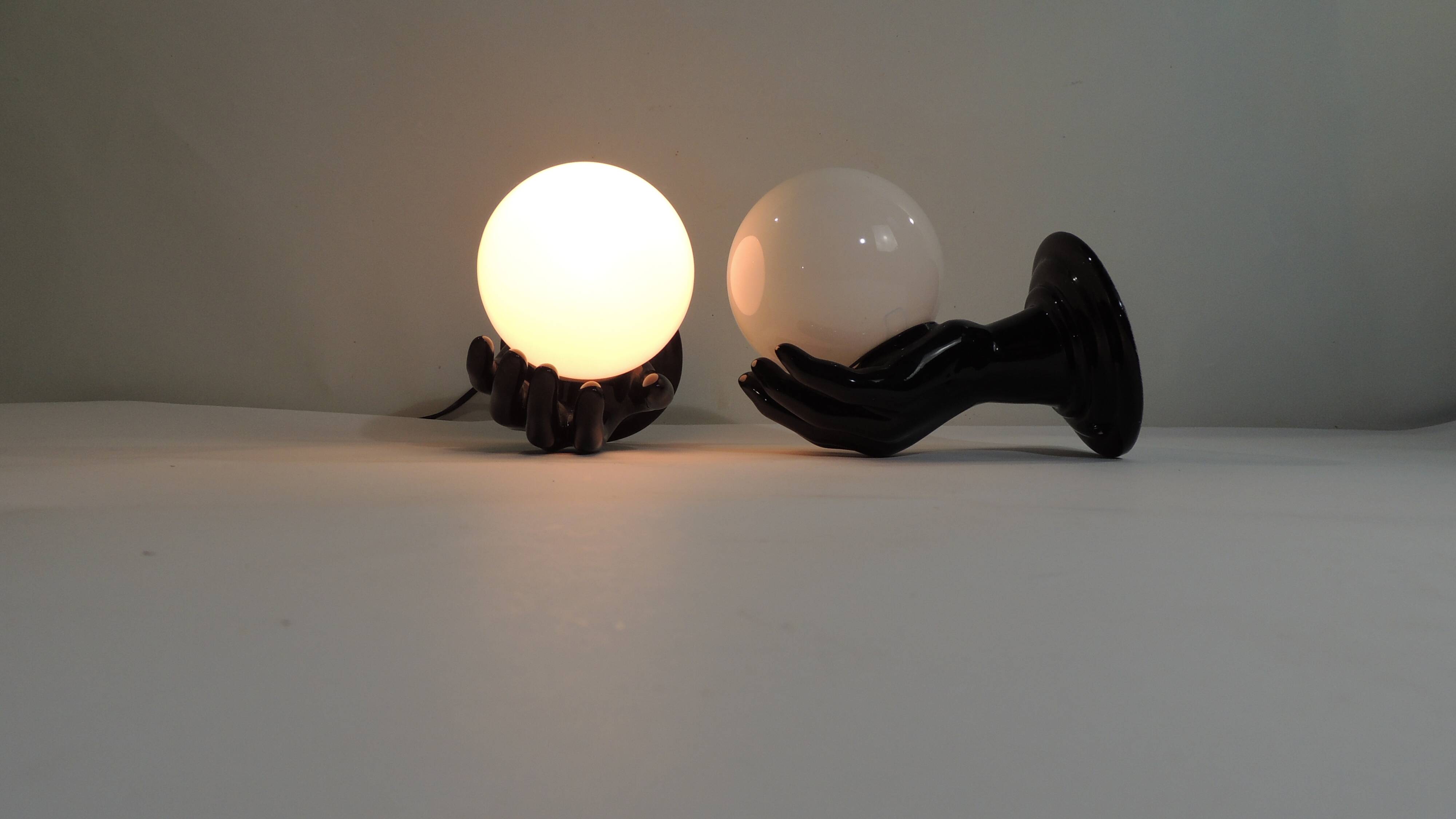 Paire d’appliques mains noires tenant un globe en opaline, années 70