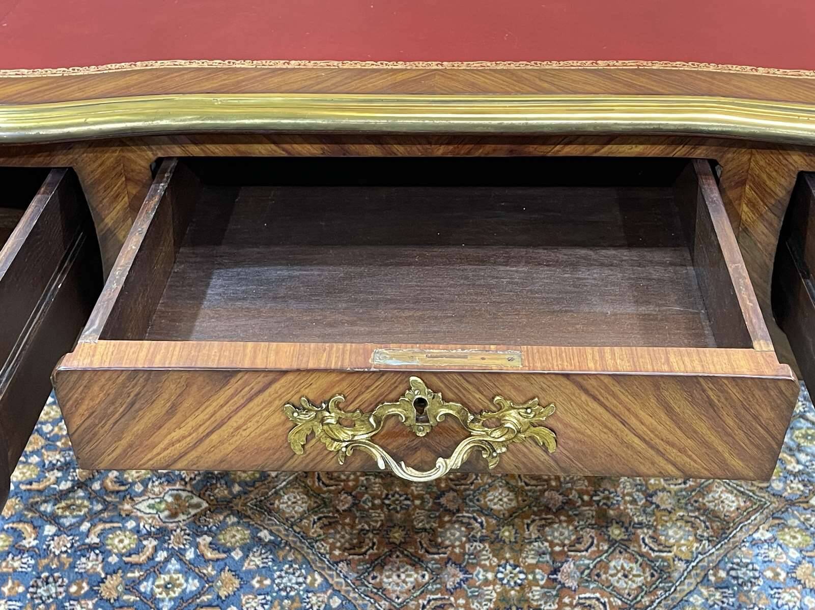 Bureau plat de style régence en placage de bois de rose, travail des années 1950