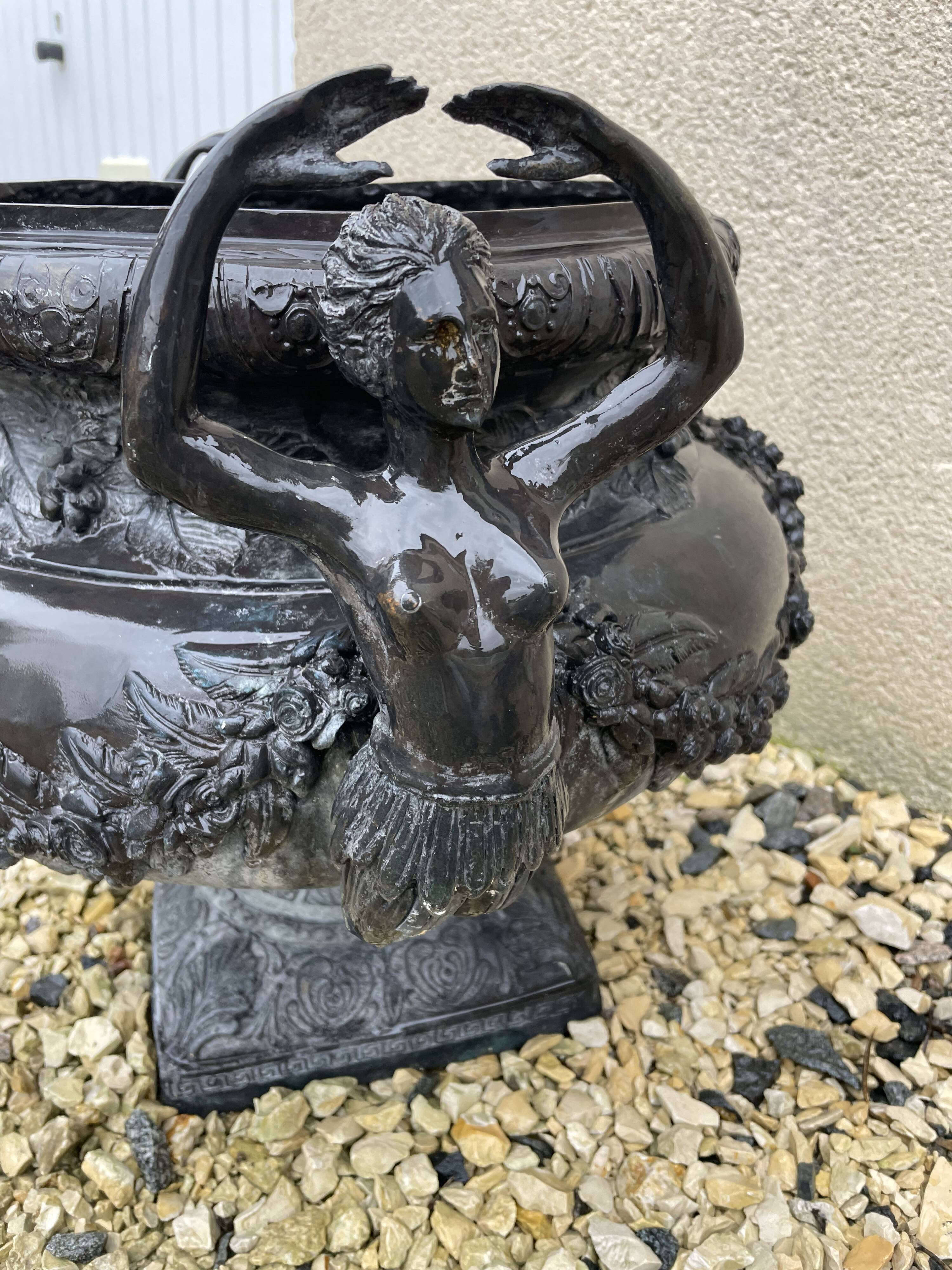 Cast iron vase decorated with mermaids.