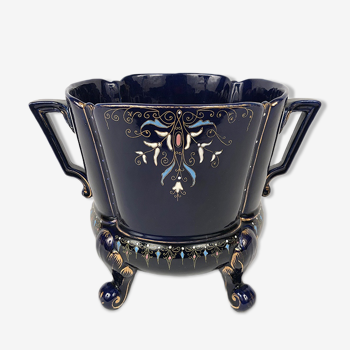 Large earthenware pot cover with enamelled decoration on a blue oven background