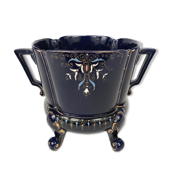 Large earthenware pot cover with enamelled decoration on a blue oven background