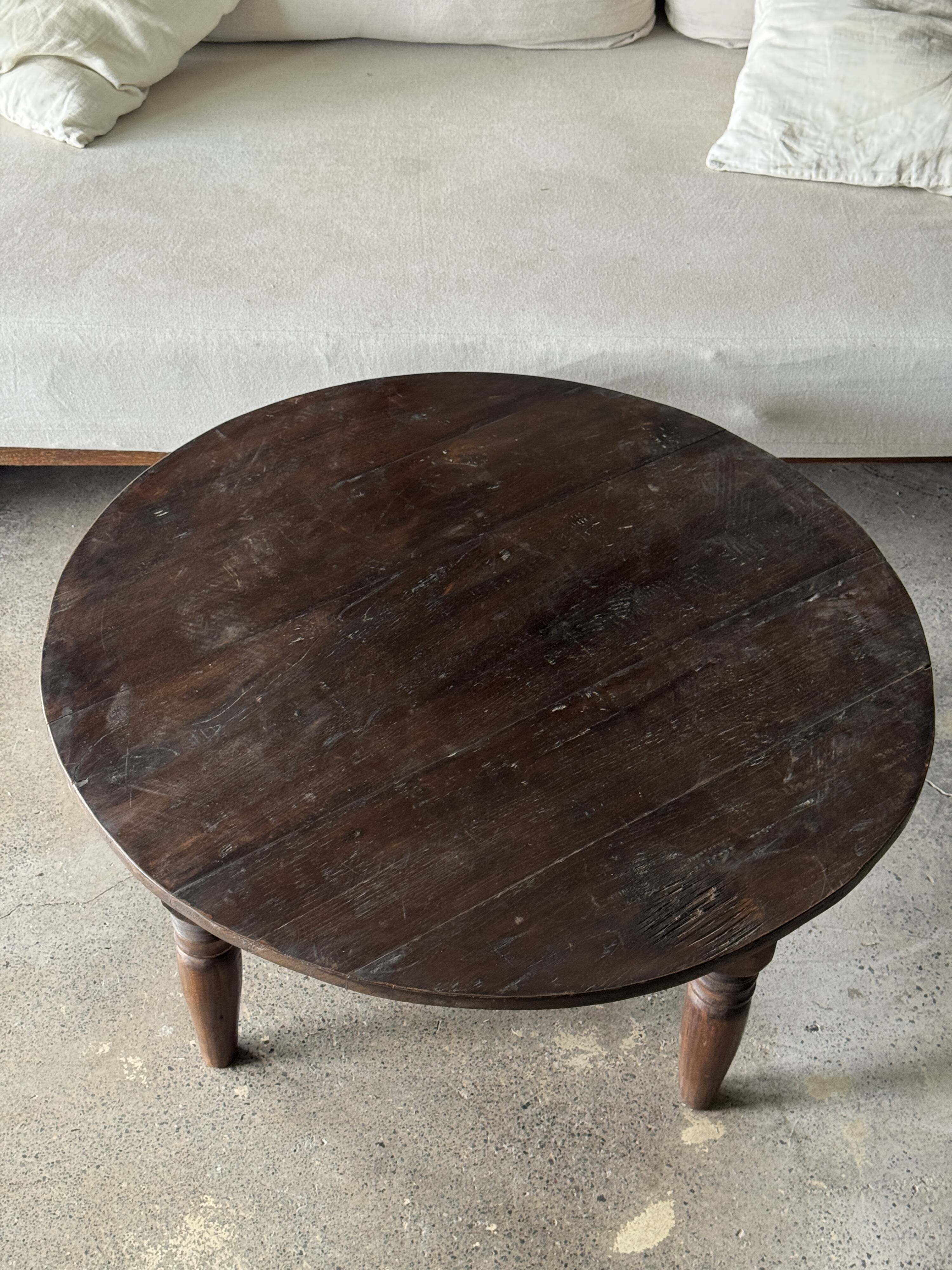 Coffee table, round antique Indonesian teak table with straight legs.