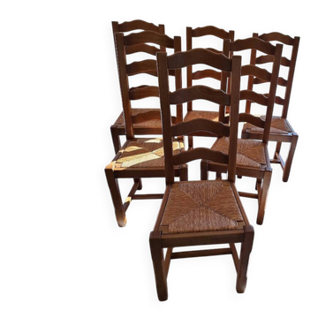Set of 6 solid oak chairs with straw seats.