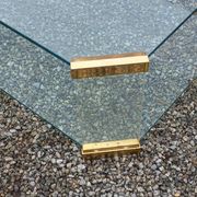 1970s designer coffee table in glass, plexiglass, and gold metal.