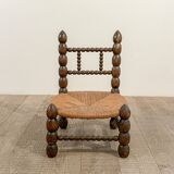 Low chair in beaded wood and straw
