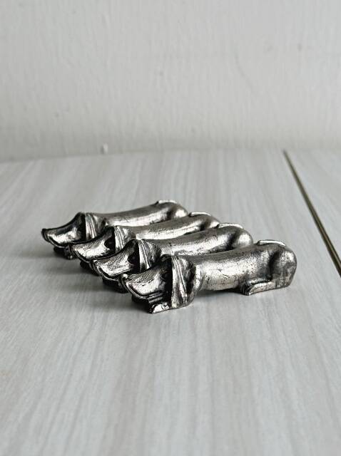 Antique metal knife rest in the shape of a dog.