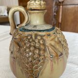 Wine pitcher in stoneware motifs grapes in relief signed Denbac