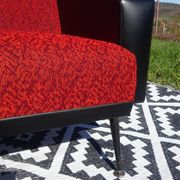 Pair of vintage armchairs in black faux leather and red fabric.