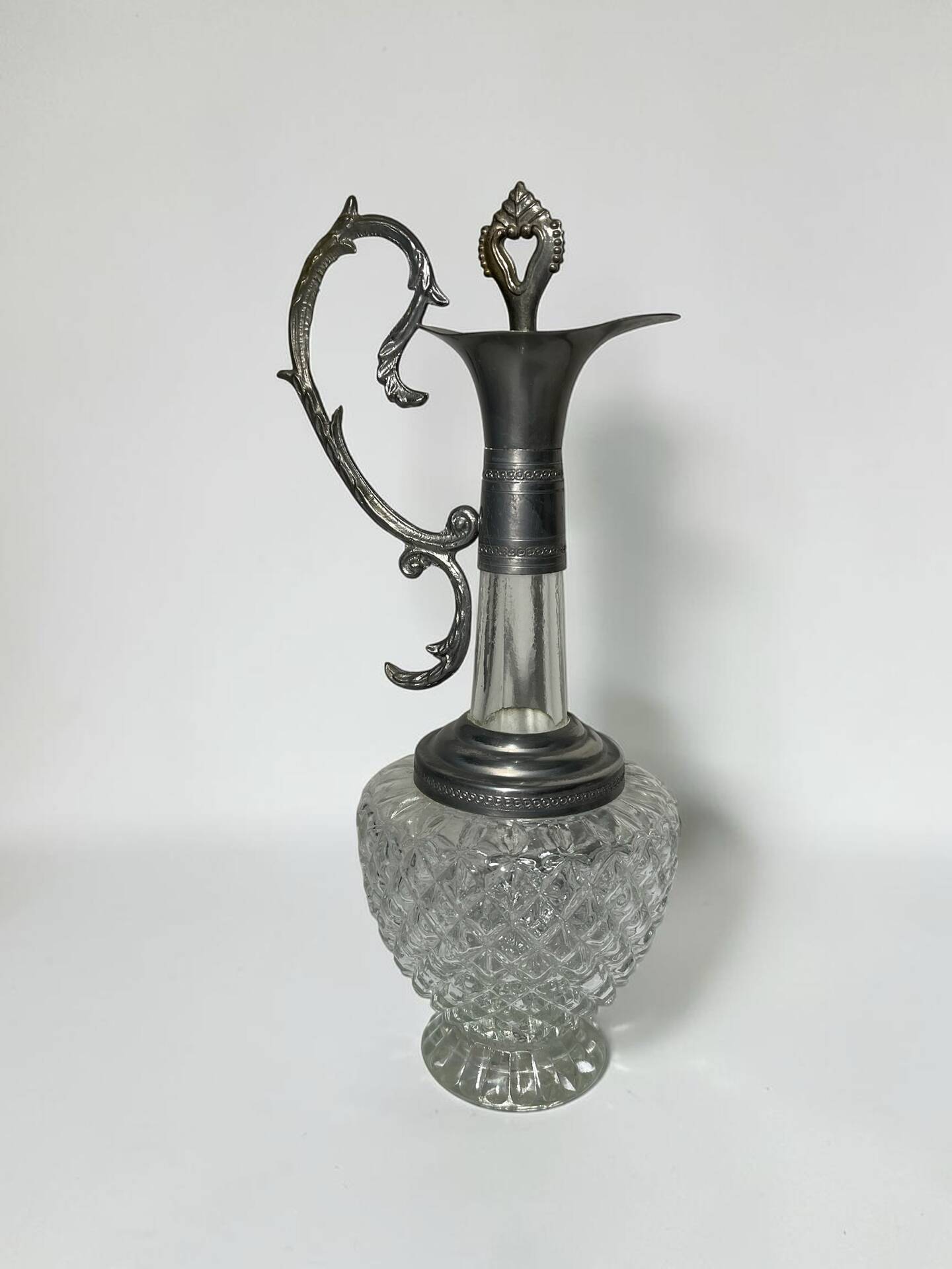 Vintage glass decanter with cut design and silver-plated metal, stopper included.