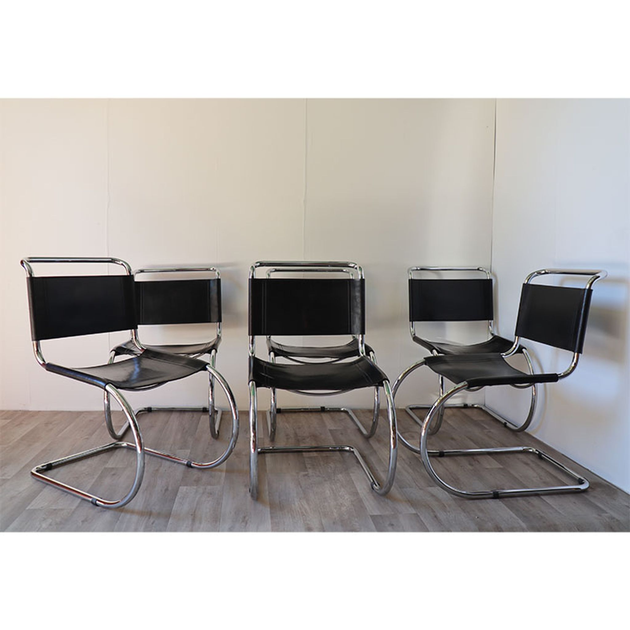 Series of 6 minimalist chairs in chrome metal and black leather around 1970
