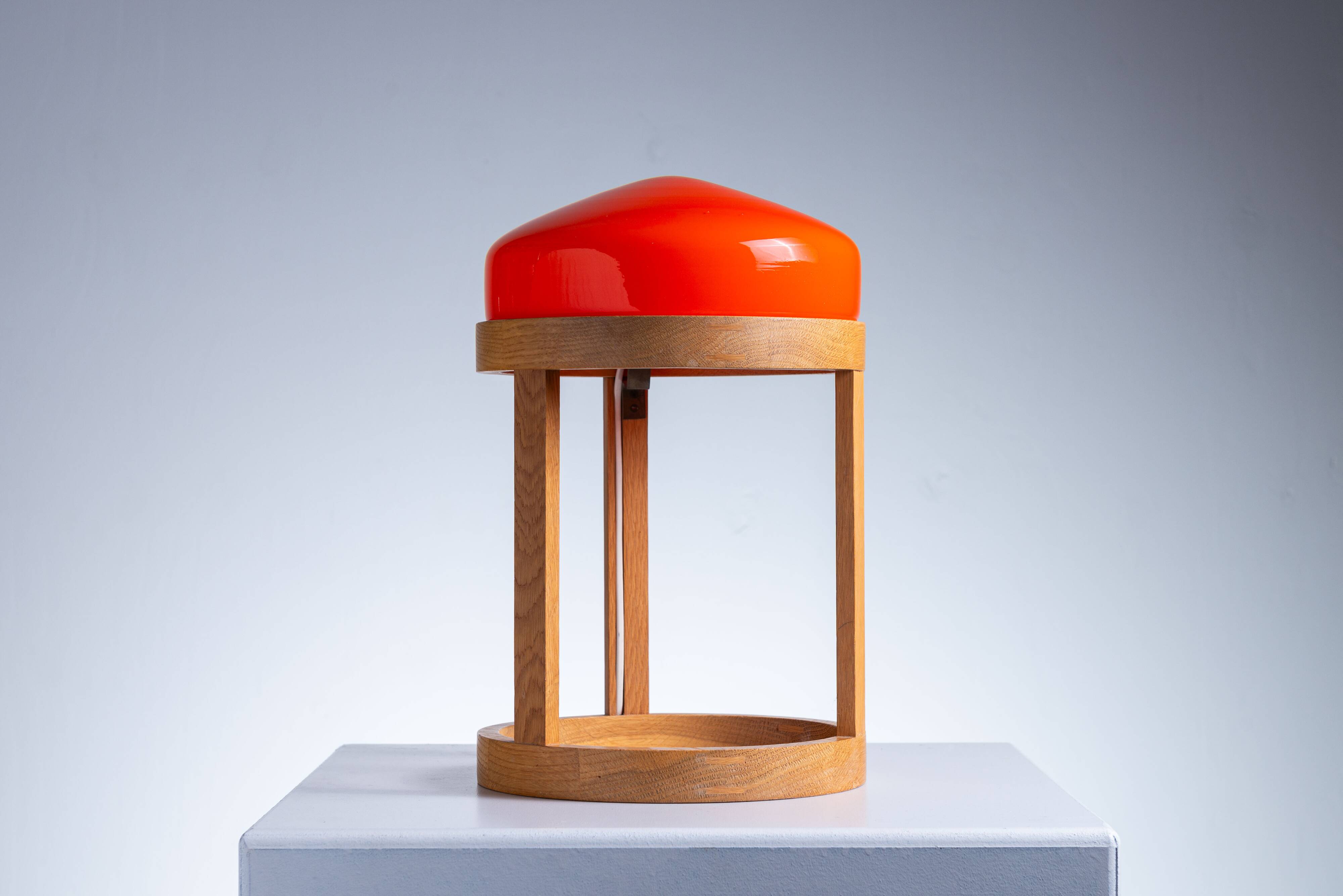 Bent oak wood table lamp with orange glass shade