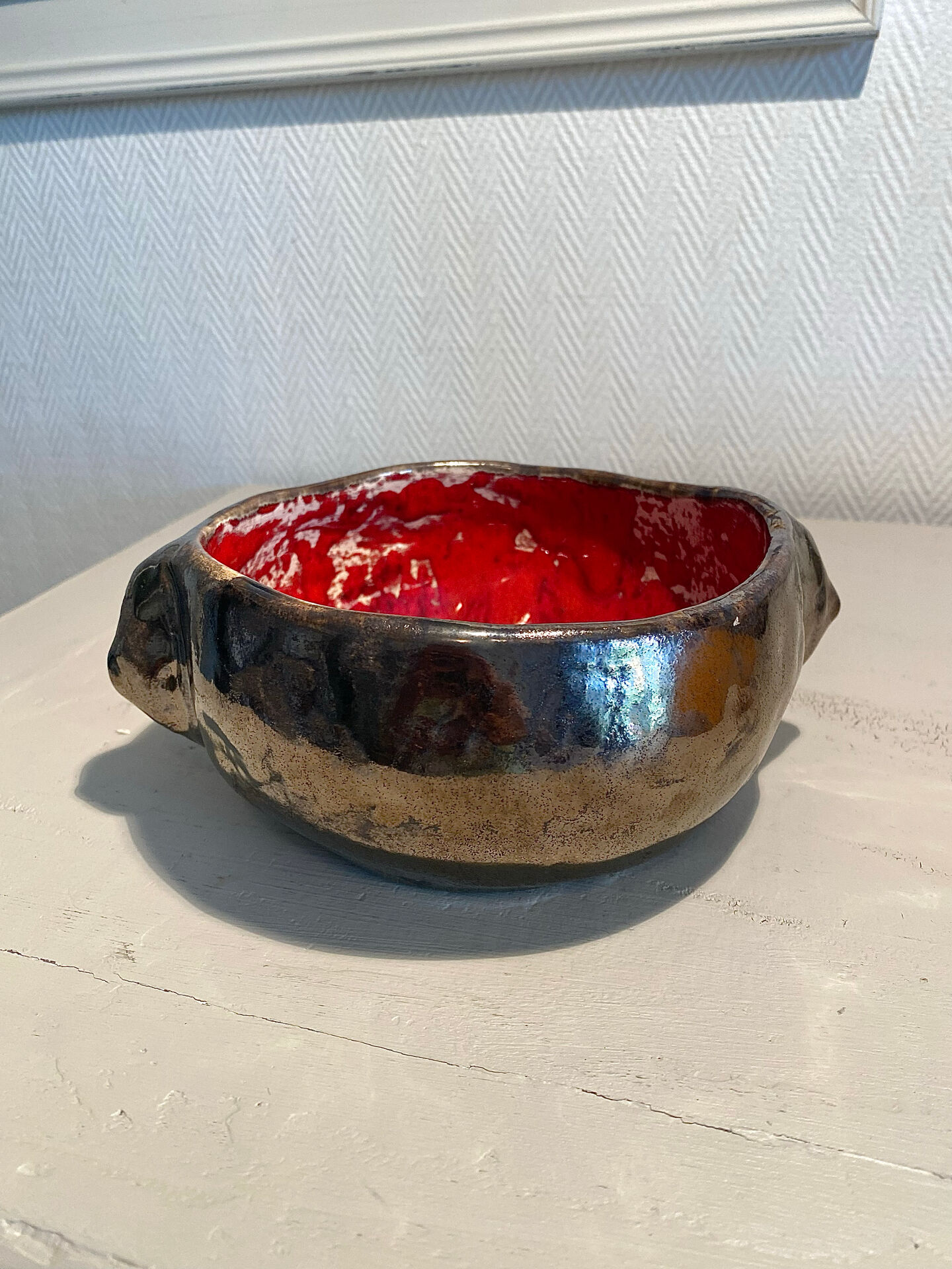 Deep red glazed and metallic ceramic catchall.