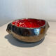 Deep red glazed and metallic ceramic catchall.