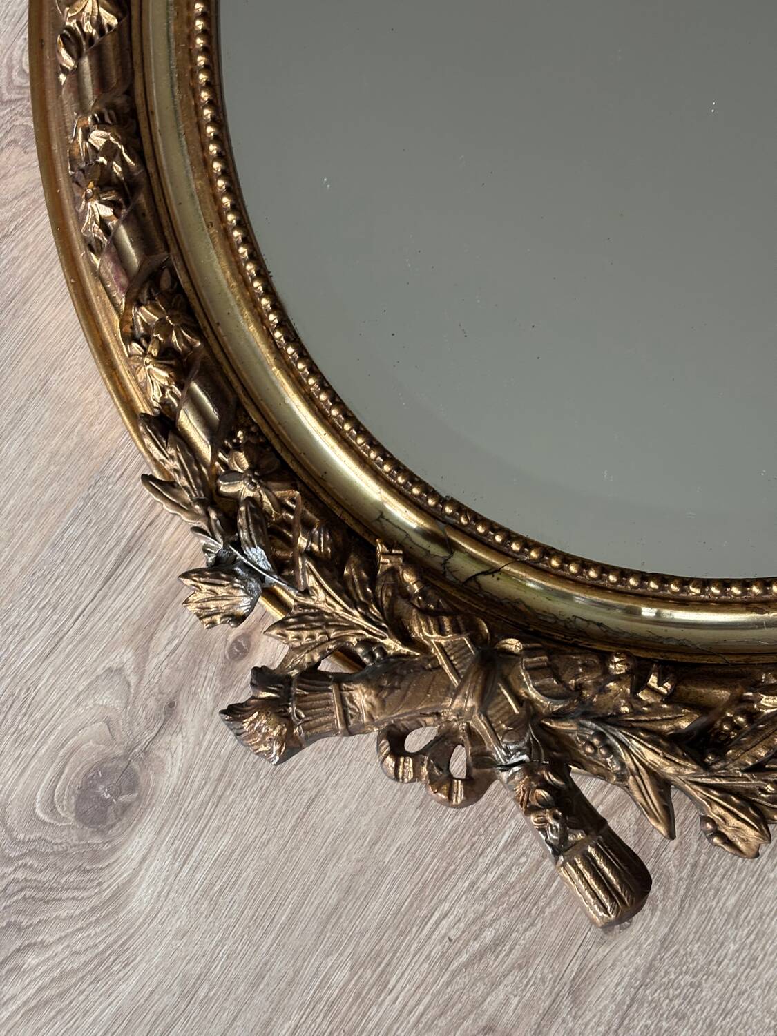 19th century oval gilded mirror, torch & quiver 106cm