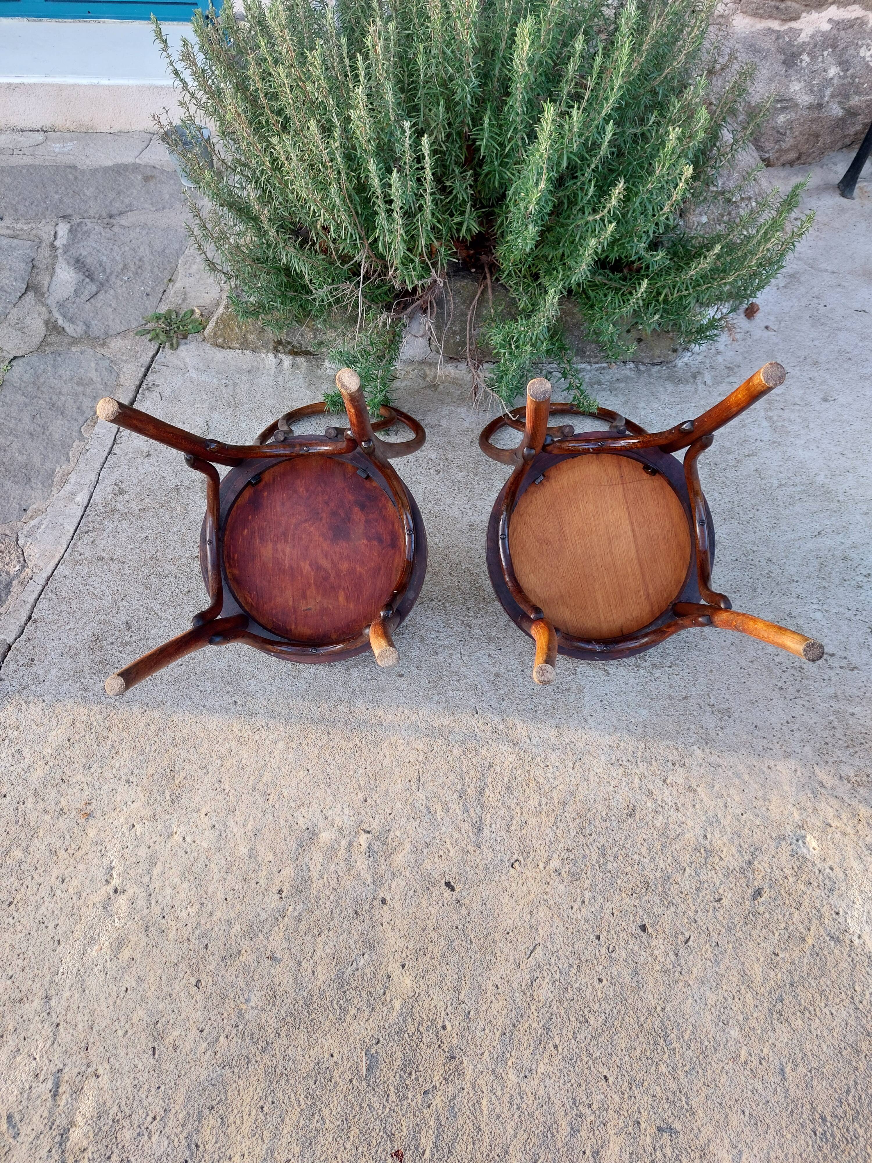 pair of round wooden chairs with a pattern on the seat